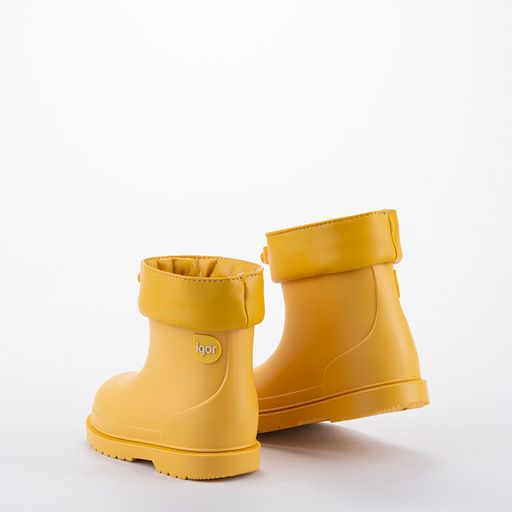 A unisex wellington boot by Igor. Style is Bimbi Euri in yellow with front toggle adjuster. Back view of a pair.