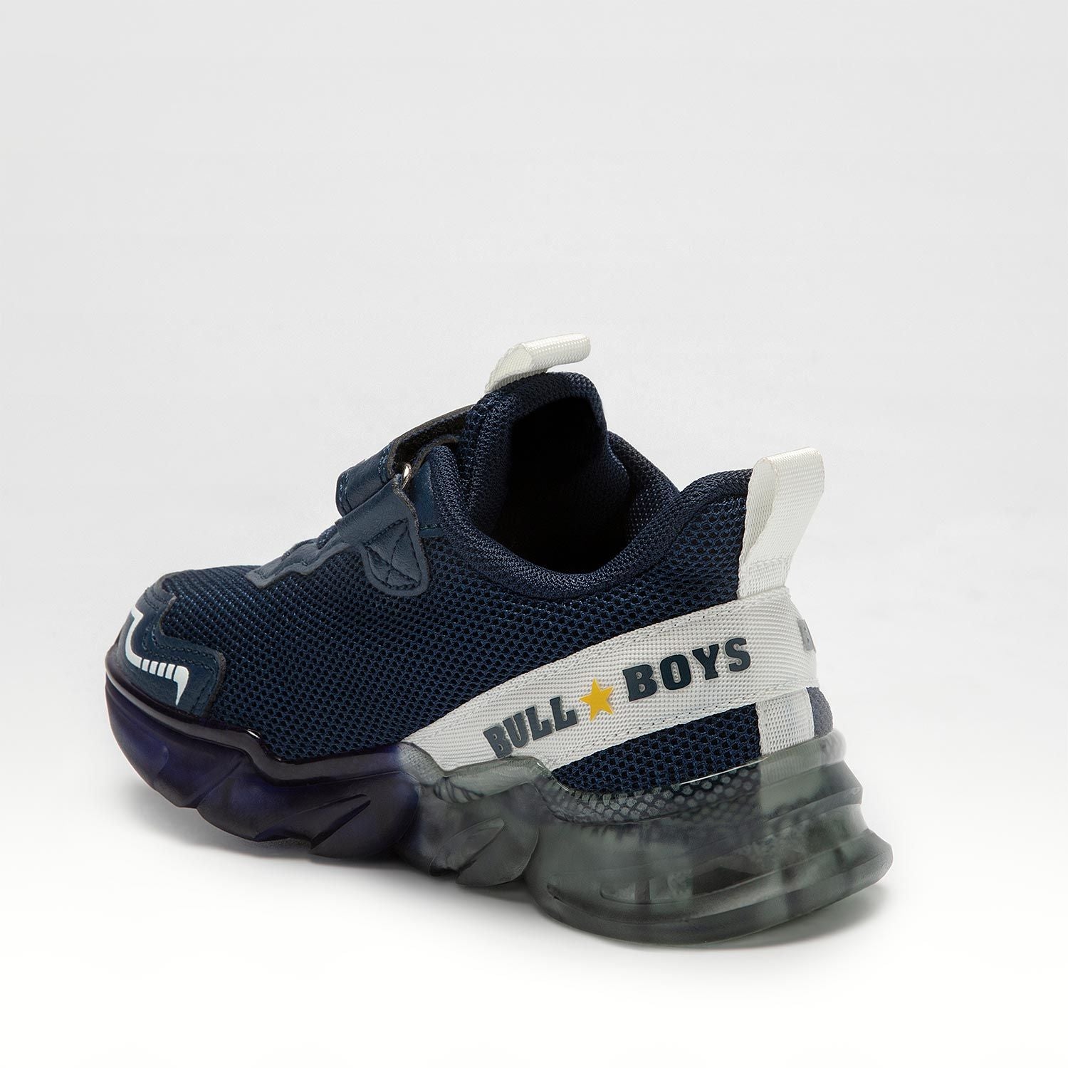 A boys trainer by Bull Boys, style Spinosauro, in navy blue with grey dinosaur in 3D and flashing sole. Velcro and elastic faux lace fastening. Back view.