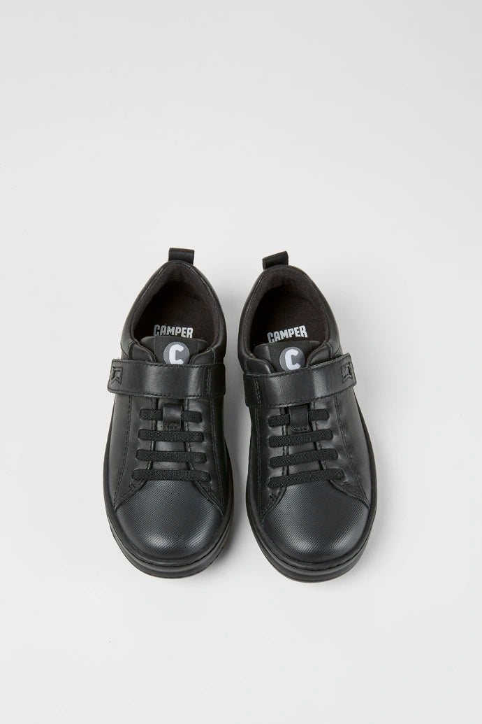 A pair of boys casual school shoes by Camper,style K800319-001 in black leather with faux lace and zip fastening. Angled view.